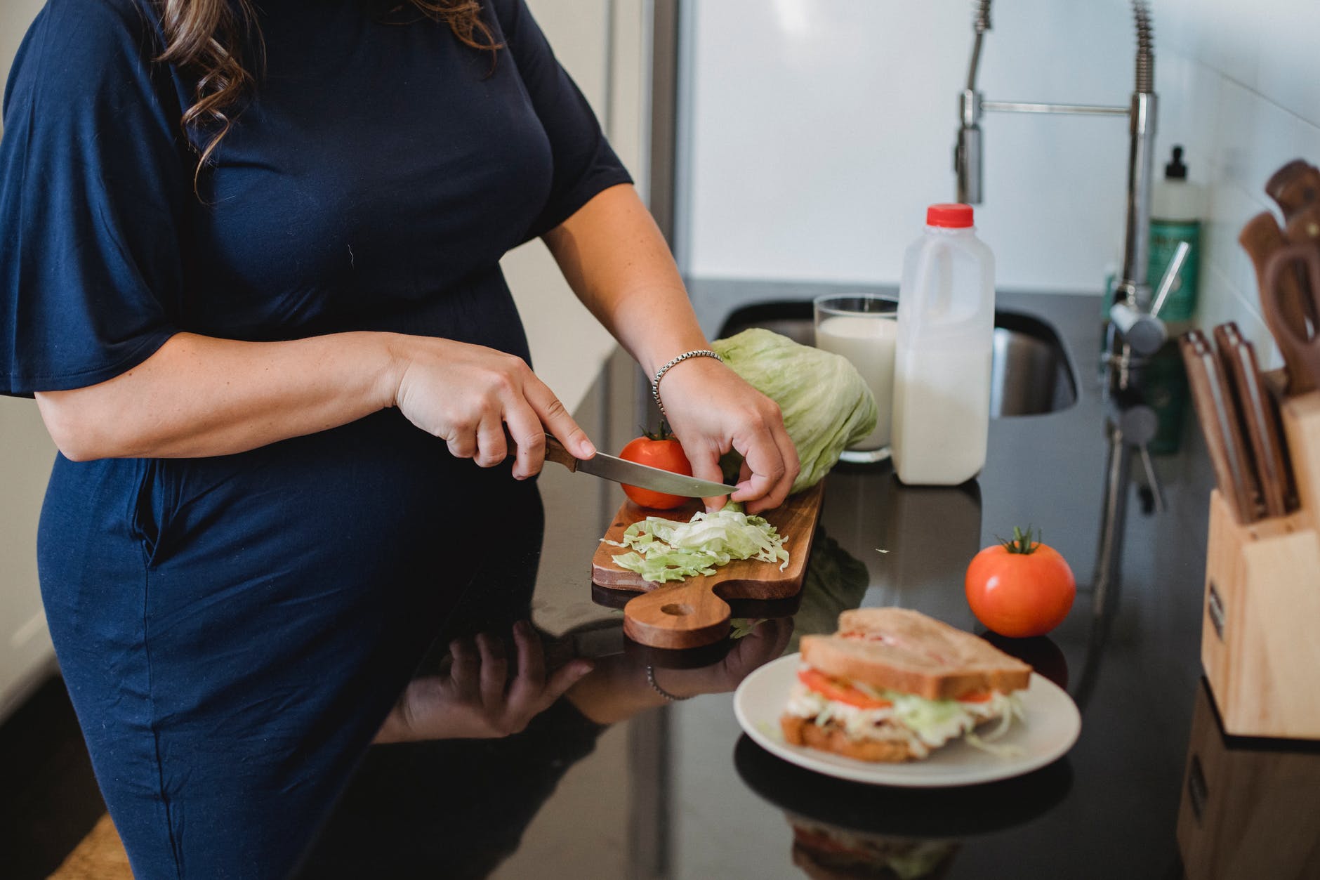 Pregnant woman making food.